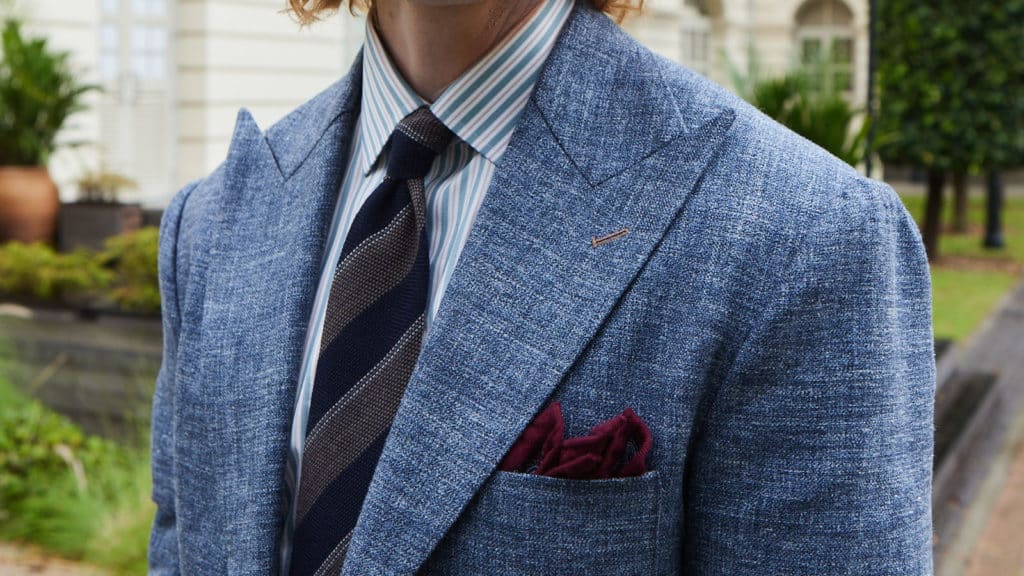 A model wears a classic blazer made with OP2317 Stone, a wool and linen fabric by Officine Paladino.
