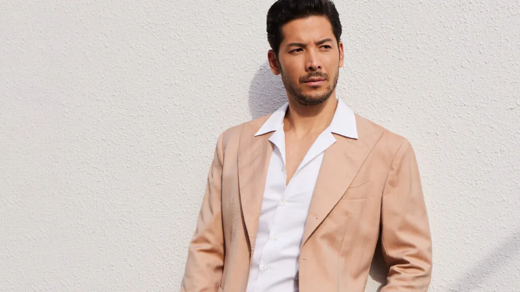 A model wears a peach herringbone wool fabric from Officine Paladino, OP2556.