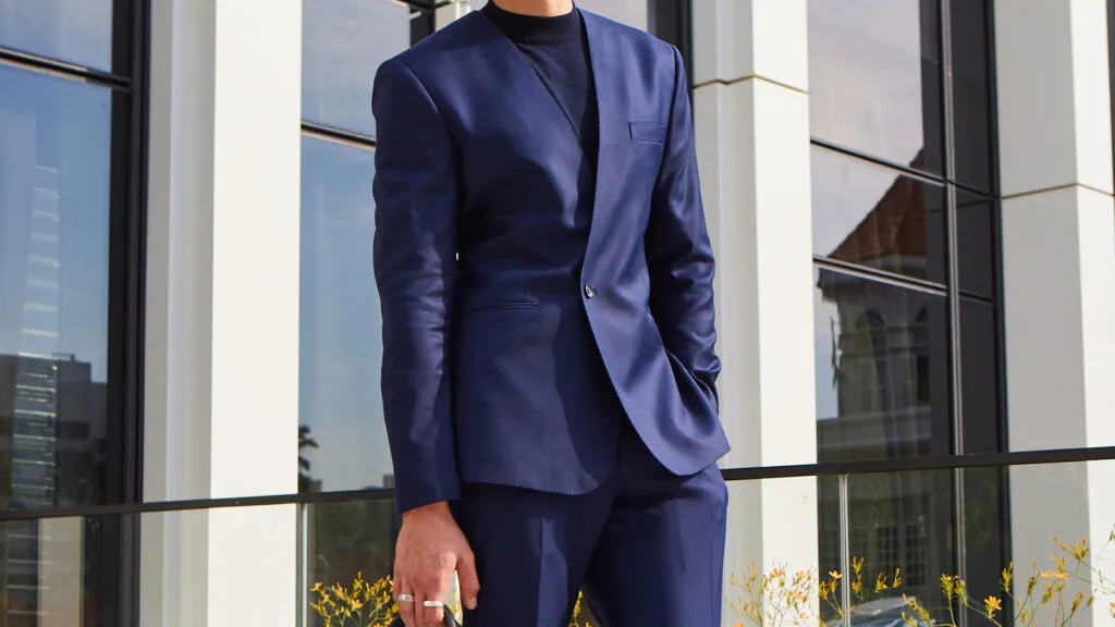 OP2504 Rogan shown here in a two-button DB without lapels, mirrors the season’s minimalist vibe inspired by the fashion of the nineties.